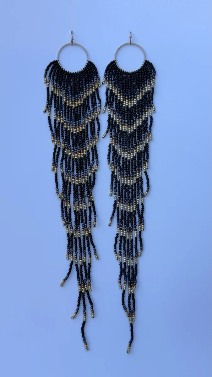 Pair of black and gold beaded fringe earrings on hoops.
