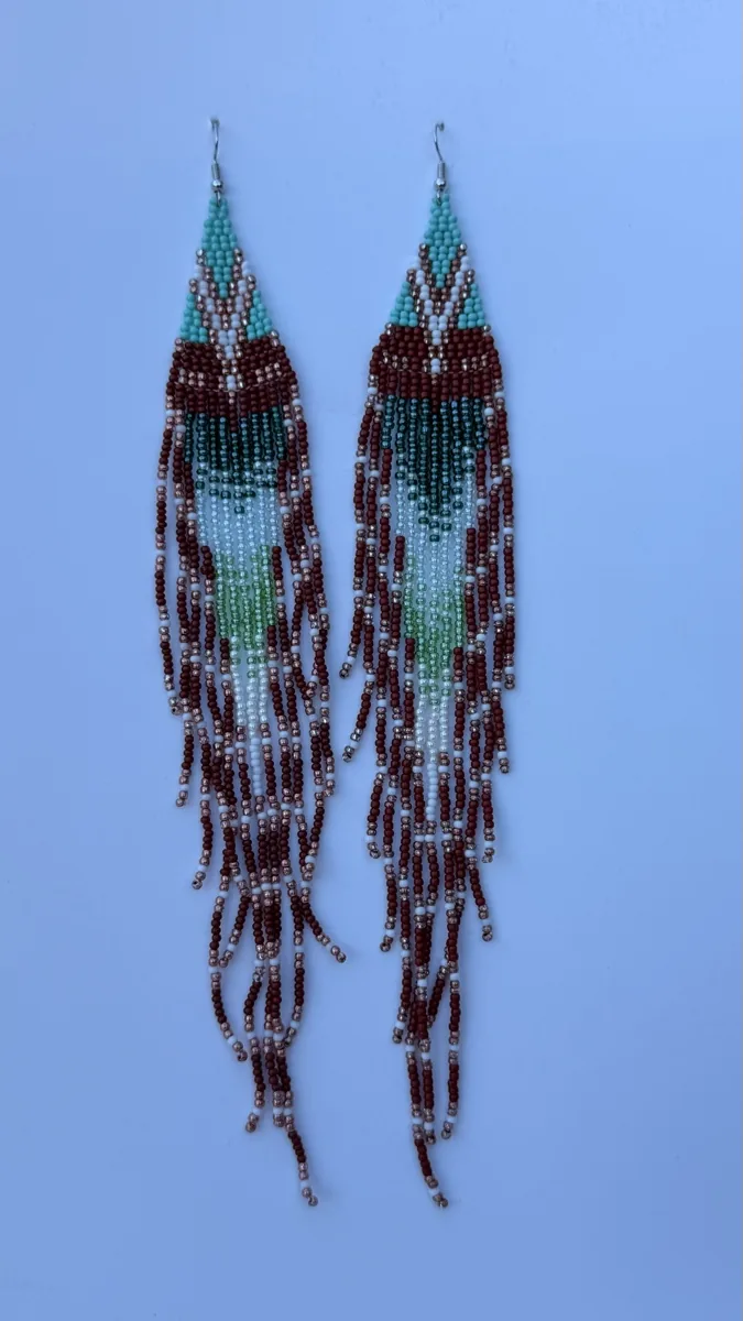 Pair of long teal and burgundy beaded fringe earrings with geometric tops.