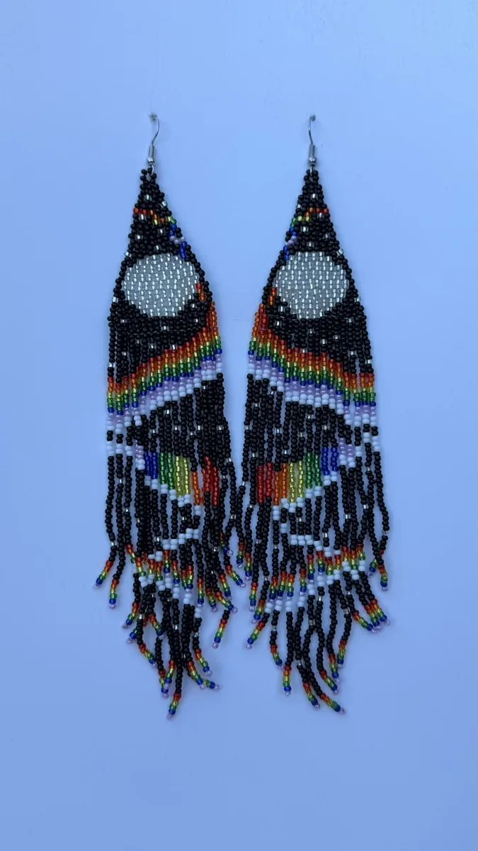 Pair of long black beaded earrings with white ovals and rainbow fringe.