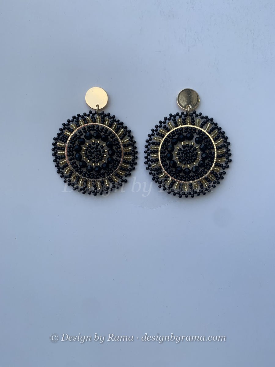 Large circular black mandala disc earrings with concentric bead rings, faceted crystal centre, and gold post stud.